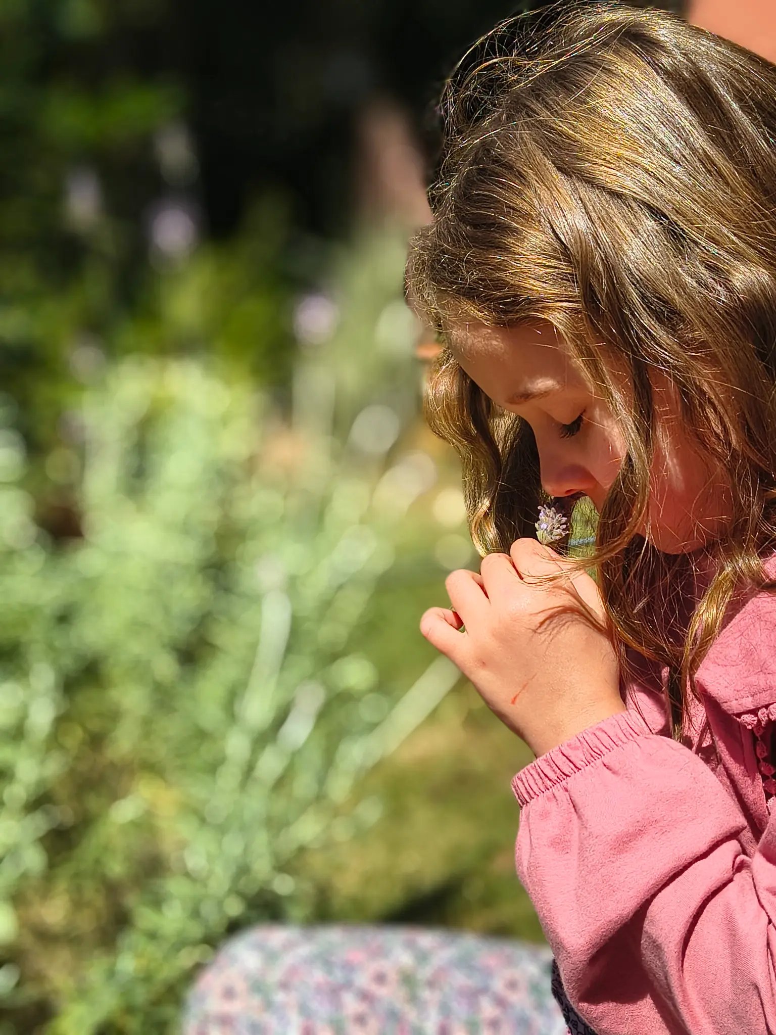 Nossa filosofia - criança cheirando flor